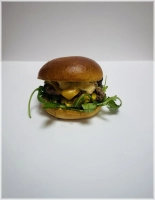 Brioche bun, Een keer patty 90 gram, Een keer cheddar, Gemengde sla, Gekarameliseerde ui en onze geheime saus  ( Foto is 2 patty's)